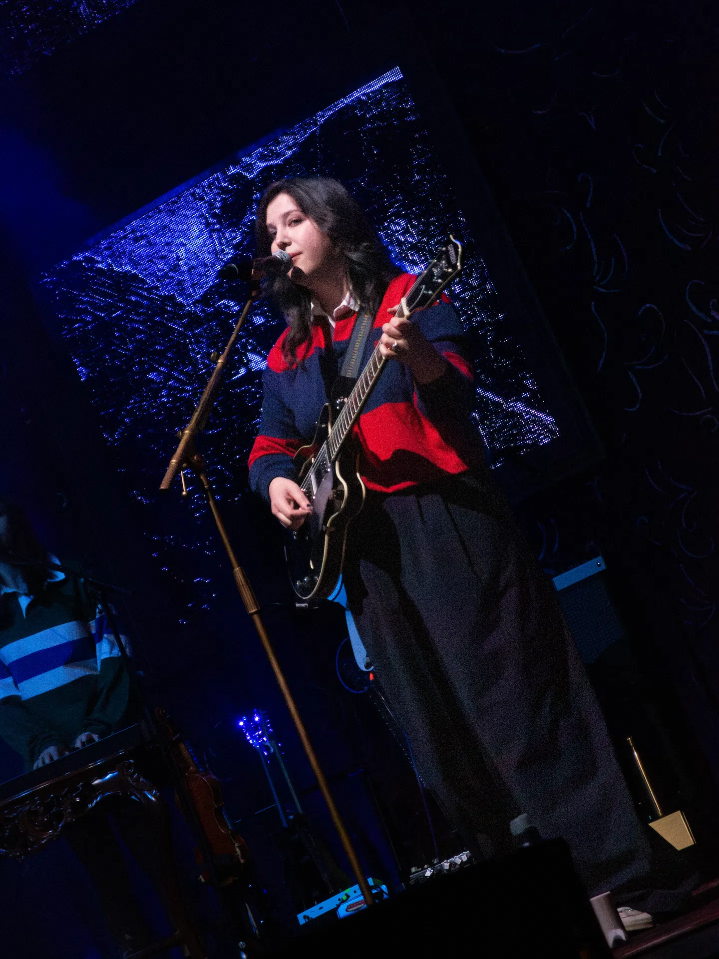 Lucy Dacus singing and playing guitar.