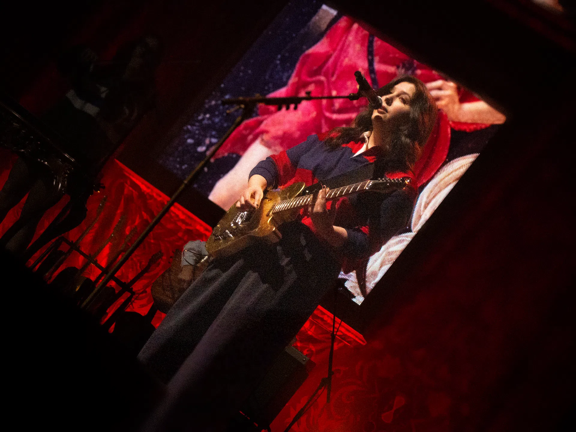 Lucy Dacus singing and playing guitar.