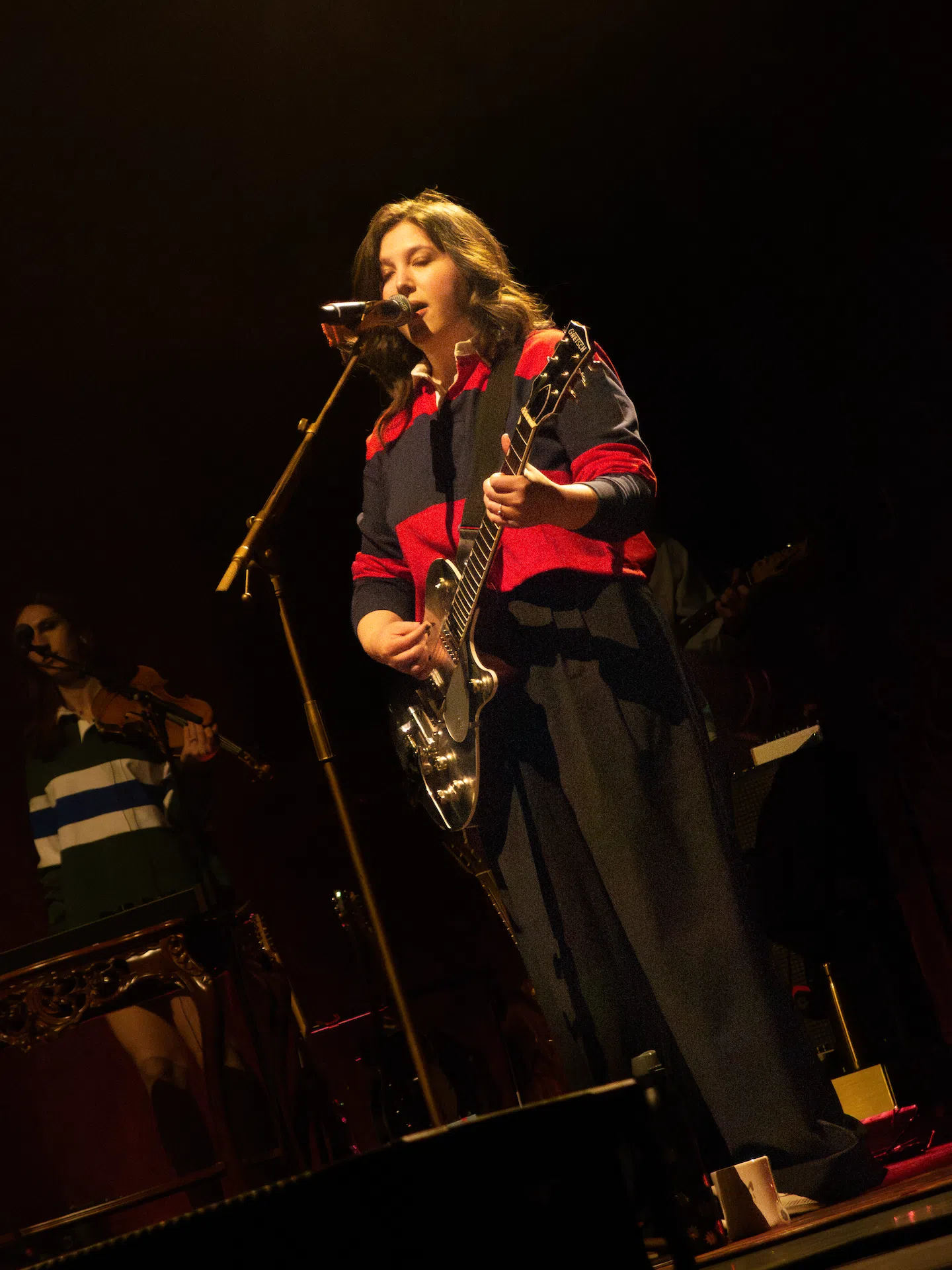 Lucy Dacus singing and playing guitar.
