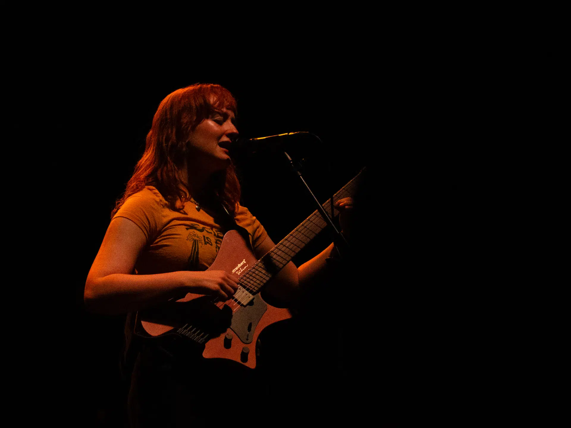 Emma Harner playing guitar and singing